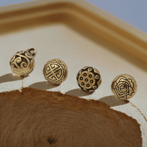 Close up of vintage brass shank buttons, showing the antique brass-tone surface and the raised detail on the face