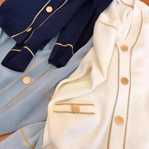Minimalist solid metal buttons sewn onto a navy garment, round flat shank buttons with a polished metal finish for coats, blazers and cardigans