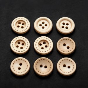 Natural wooden buttons with a printed dashed stitch edge in several sizes on a dark background, two-hole and four-hole sew-through buttons for sewing and crafts