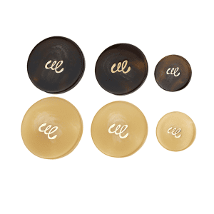 Resin monogram buttons grouped in black and cream with a gold-tone monogram