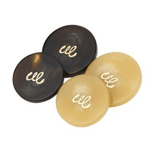 Close-up of resin monogram buttons with a gold-tone monogram in black and cream