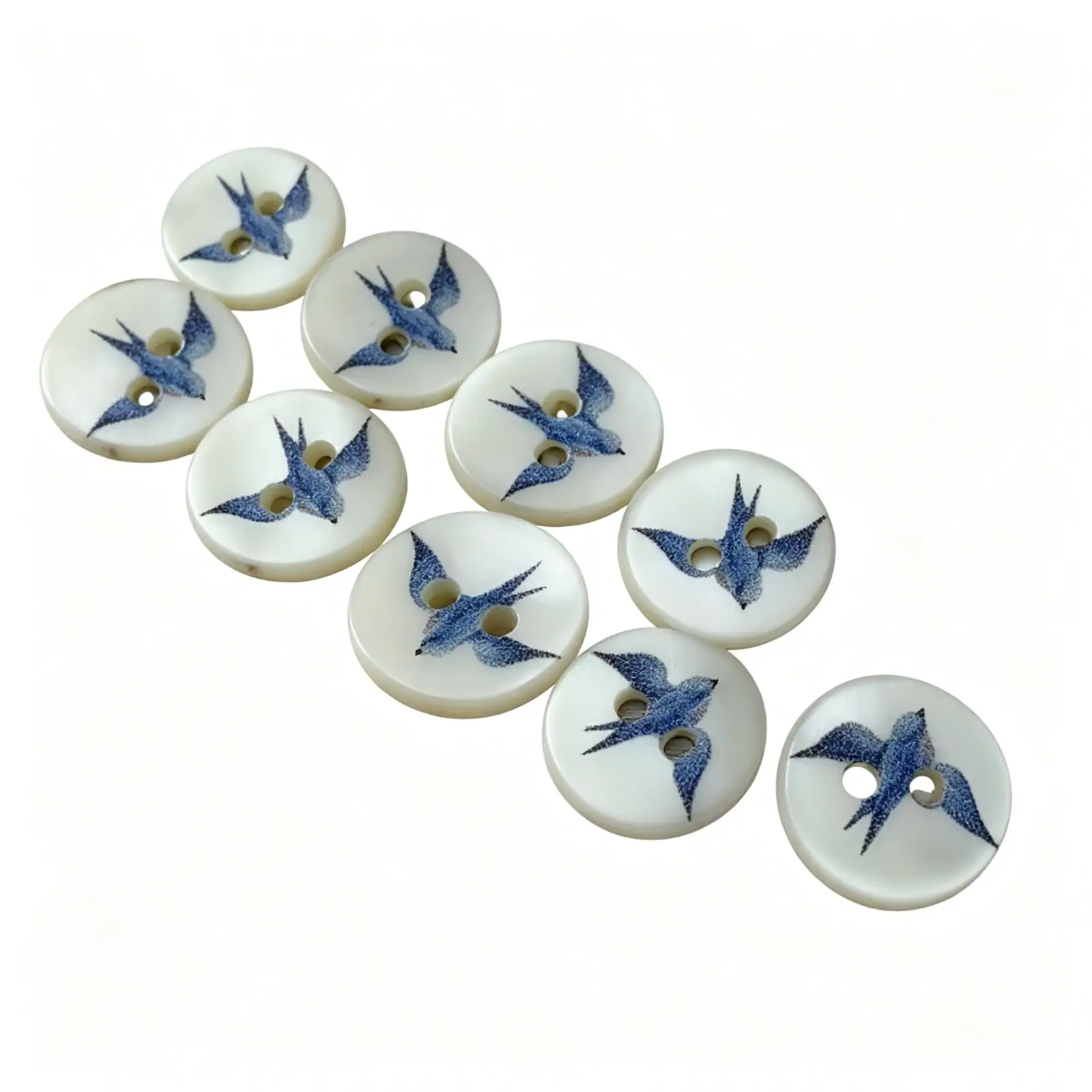 Nine blue swallow shell buttons laid out diagonally on a white background