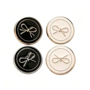 Four bow enamel buttons arranged in a square, showing black and cream faces with gold-tone and silver-tone metal frames