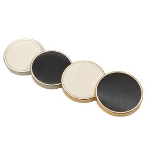 Close-up of black and white vintage enamel buttons with a metal rim