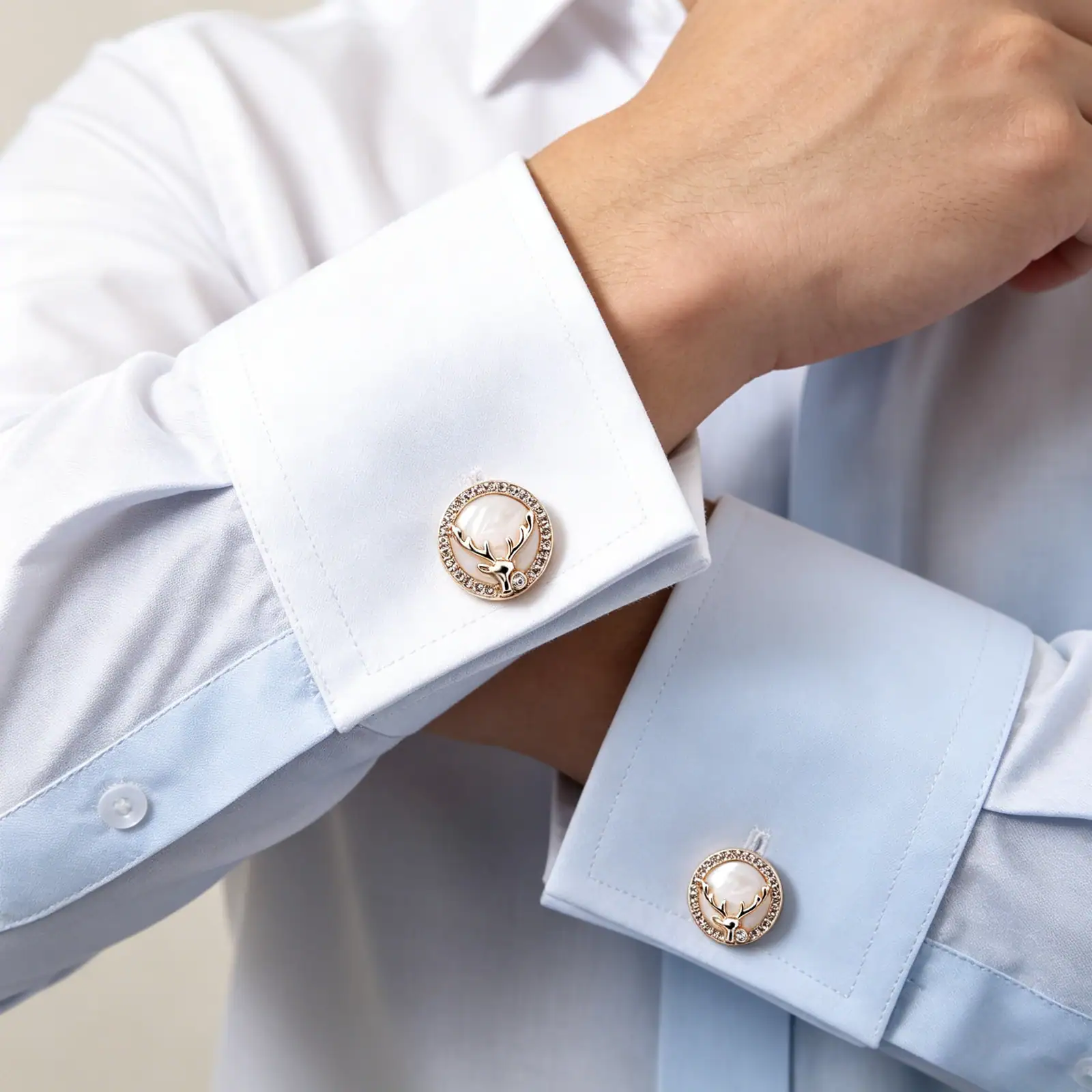 Gold-tone deer head rhinestone metal buttons sewn onto white and pale blue shirt cuffs