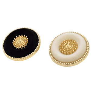 Close-up of black and cream vintage flocked buttons with a flocked-fabric finish and gold-tone rim