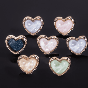 Glitter heart buttons in black, white, mint green, lavender, pale yellow, sky blue and blush pink with gold-tone toothed frames, for cardigans and DIY sewing