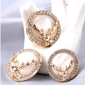 Deer rhinestone shell buttons styled on cloth with a deer design and faceted rhinestones