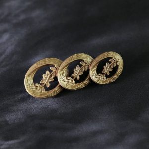 Laurel leaf buttons in vintage gold, three openwork oval metal sew-on buttons with woven rims and leaf sprigs