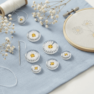 Small daisy resin buttons styled on a surface, daisy-shaped resin buttons with two holes