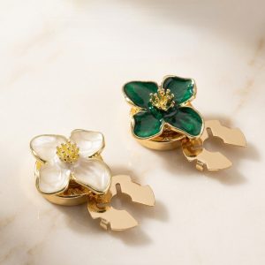 Cream and green enamel flower button covers side by side, glossy four-petal flowers with a gold-tone stamen center, snap-on