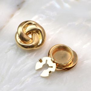 Close-up of gold-tone twisted knot cufflink cover