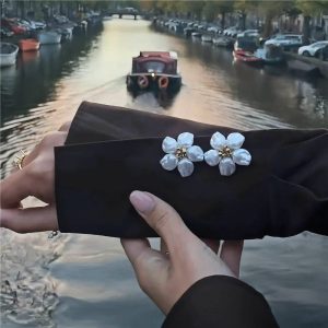 Pearl flower button covers worn on a black garment for a dressed-up floral look