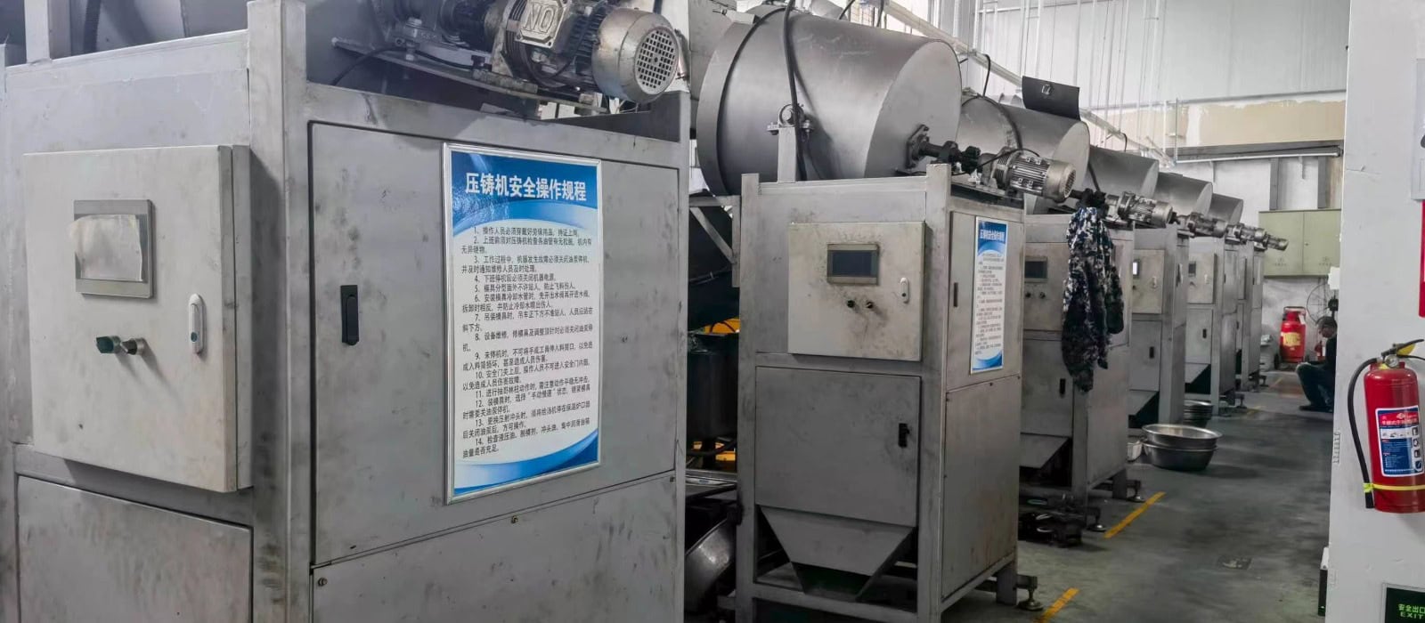 Row of die-casting machines in a button manufacturing factory workshop, producing metal buttons