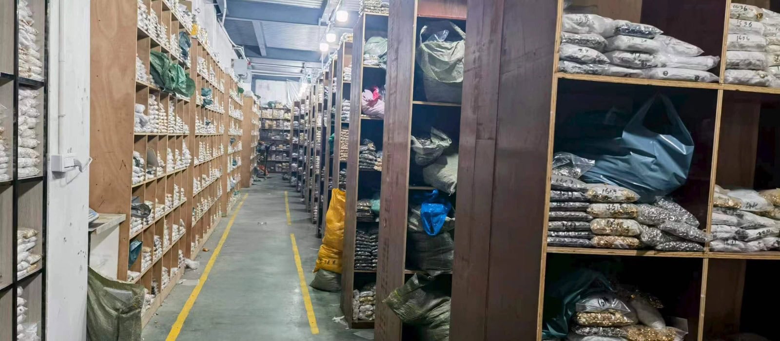 Aisle of shelves stocked with bags of buttons in a button warehouse, large wholesale inventory