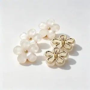Four cherry blossom flower buttons with pearly five-petal faces and small gold-tone centres, two shown face up and two showing the gold-tone backs