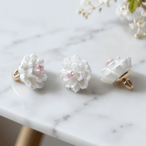 White camellia flower buttons with layered white petals and a pink center on a gold-tone metal shank, floral shank buttons for cardigans, blouses and DIY sewing