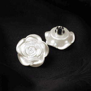 Cluster of white faux pearl rose buttons on a dark background
