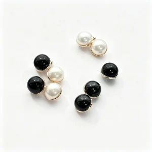 Faux pearl and black mushroom buttons with gold-tone rims on white background