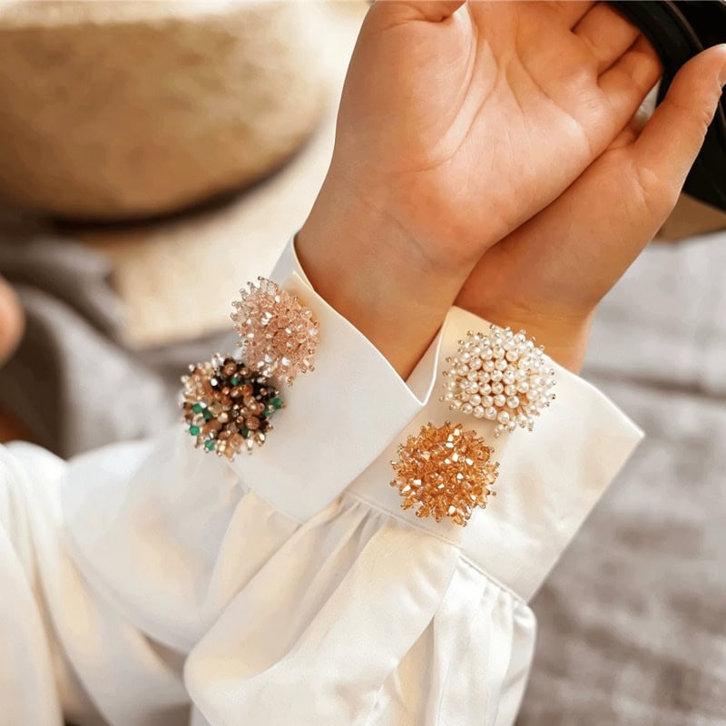 French cuff flower button covers styled on folded napkins, beaded flower accents for a wedding table setting