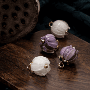 Lily of the valley glass buttons on wood with a lotus pod, white and purple handmade flower buds with a green leaf and gold-tone loops