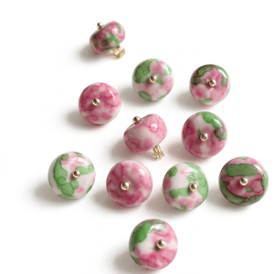 Group of red rose natural stone buttons with a pink, red and green pattern on a light background