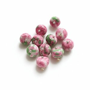 Close-up of round red rose stone buttons showing the domed bead and gold-tone shank