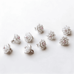 A group of white camellia flower buttons with pink centers and gold-tone shanks, floral sew-on buttons for cardigans and blouses