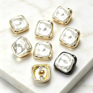 Irregular cardigan buttons in gold-tone, silver-tone and gunmetal, softly squared buttons with a pearlescent face