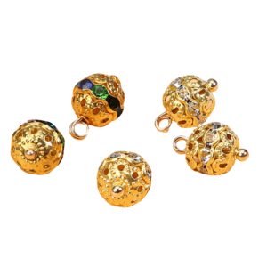 Scattered gold-tone rhinestone ball buttons showing the cut-out metal pattern and stone-set band