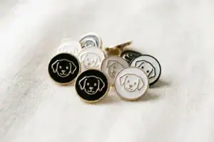 Dog buttons in black and white enamel with gold-tone and black rims, 11mm shank buttons with a raised puppy face