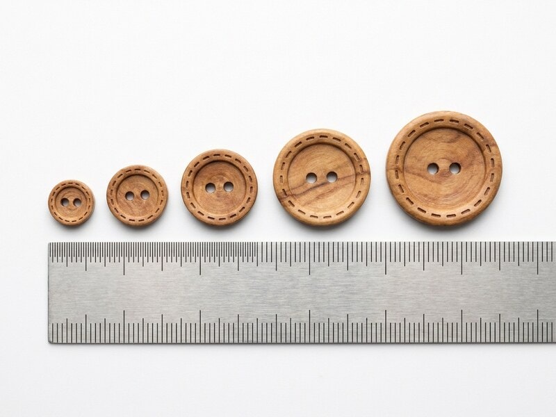 Natural wood buttons size comparison from 10mm to 23mm shown next to a ruler