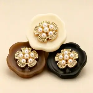 Three pearl cluster flower buttons stacked together showing the cream, marbled brown and black colourways side by side