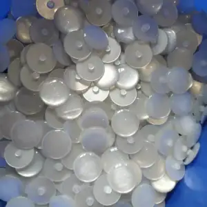 Loose pearlescent resin buttons showing flat backs with centre shanks
