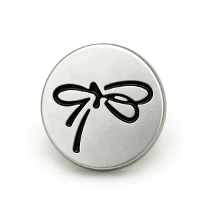 Three silver bow buttons with a matte silver-tone face and a raised ribbon bow outline in cream, black and pink