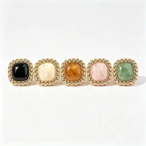 Five square chain link buttons in black, cream, brown, pink and green, each with a gold-tone chain-link rim around a domed marble-look resin face