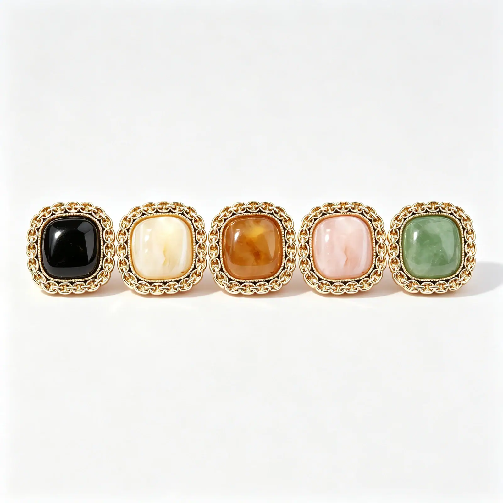 Five square chain link buttons in black, cream, brown, pink and green, each with a gold-tone chain-link rim around a domed marble-look resin face