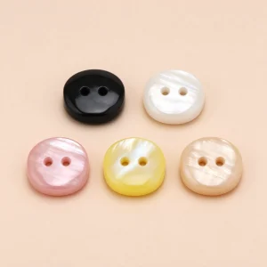 Five square resin buttons with a pearl-look sheen in black, white, pink, yellow and cream, each with two centre holes