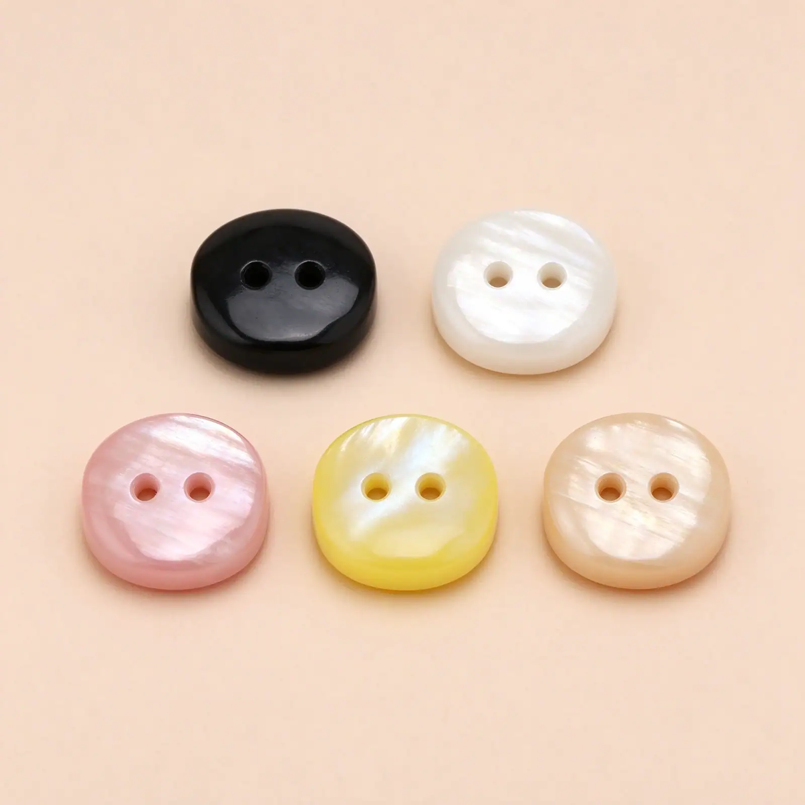 Five square resin buttons with a pearl-look sheen in black, white, pink, yellow and cream, each with two centre holes